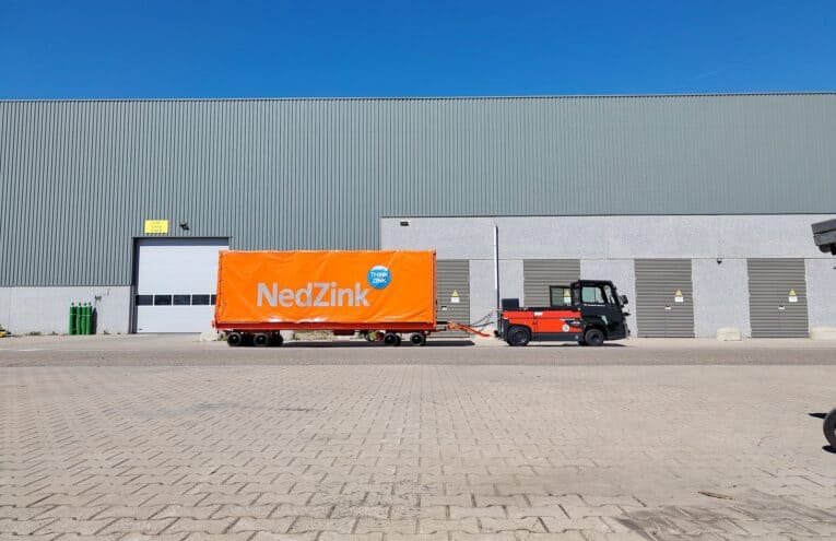 HULCK 35-tons zwaarlastwagen met NETCAP-huif, getrokken door een elektrische trekker van Van Deurzen Heftrucks, op het terrein van NedZink